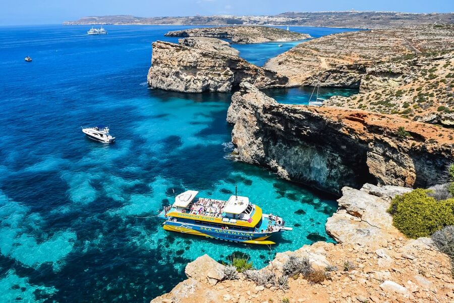 From Bugibba: Blue Lagoon Afternoon Swim with Sunset Cruise - Santa Maria Caves photo stop, then sunset over Malta’s cliffs